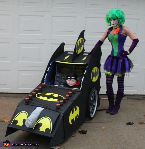 Batman in his Batmobile with the Joker Costume
