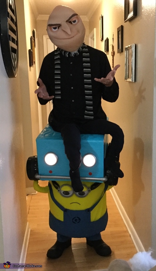 Gru in Lucy Wildes car held by a Minion Costume